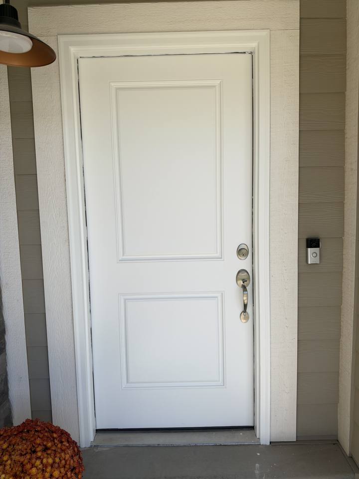The same front door after painting, with a clean, even white finish
